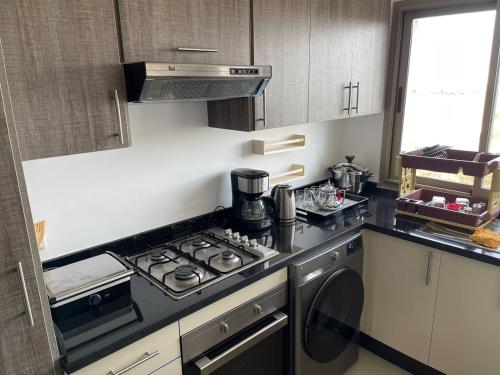 una cocina con estufa y hornilla horno superior en APPART AMIR Belle Appartement avec pecine, en Dar Bouazza