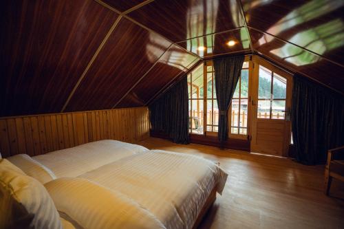 a bedroom with a large bed in a room with windows at Azure Lagoon Resort 