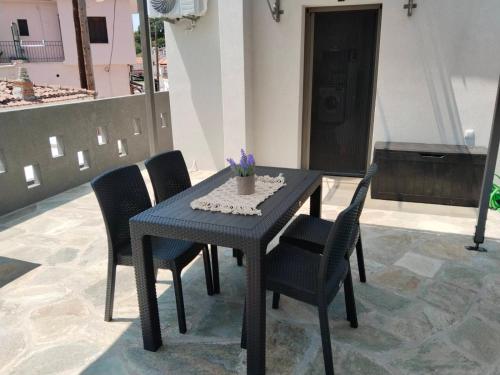 a blue table and chairs with a vase on it at Aggelikas Guest House in Tríkeri