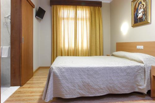 Ένα ή περισσότερα κρεβάτια σε δωμάτιο στο Domus Pacis Fatima Hotel