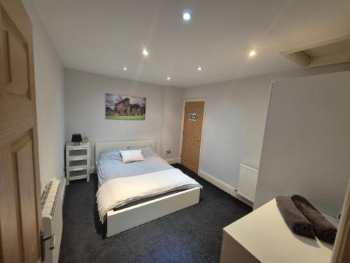 a small bedroom with a bed and a desk at Spacious 2 bed appartment next to BAE with spa bath in Barrow in Furness