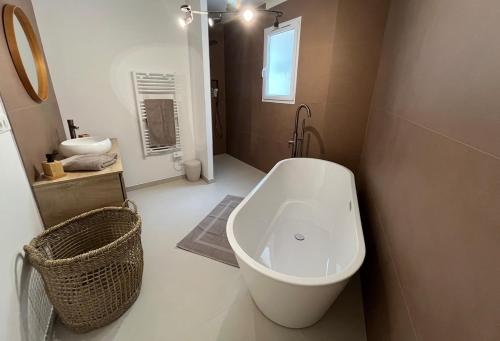 une salle de bain avec une baignoire blanche et un lavabo dans l'établissement Calvi - A Casa di u Mare, à Calvi