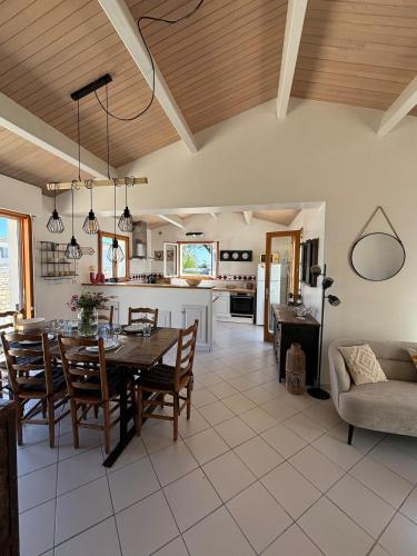 une cuisine et un salon avec une table et des chaises dans l'établissement Jolie maison à 50 m de la plage, à Rivedoux-Plage