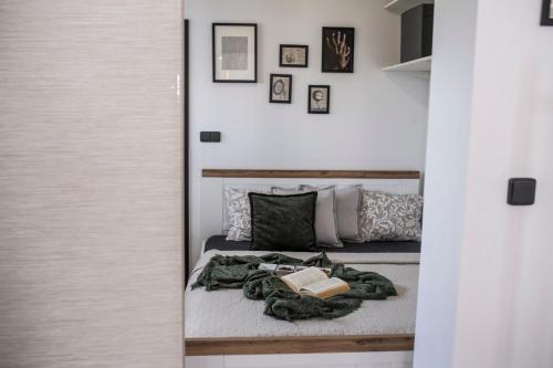 a bedroom with a bed with a book on it at MFapartments in Vrbovec