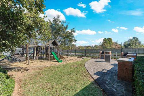 a park with a playground with a slide at Luxury & Secure apartment - Fourways in Sandton