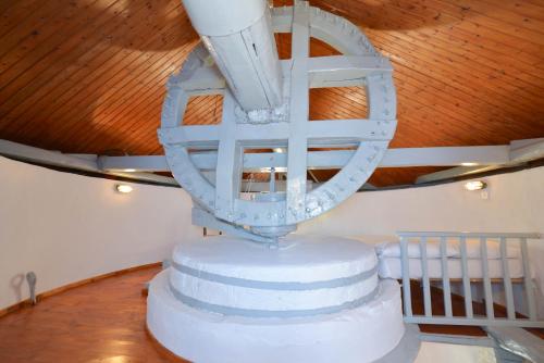 a three tiered wedding cake with a chandelier at Windmill Villas in Artemonas
