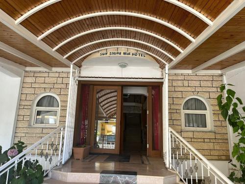 a entrance to a building with a sign on it at Sun Shine Mir Otel in Eskiömerler