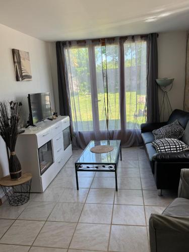 un salon avec un canapé et une table dans l'établissement Maison calme en campagne, à Archingeay