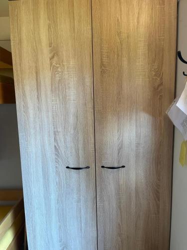a wooden cabinet with two handles in a room at Chaty u lesa 