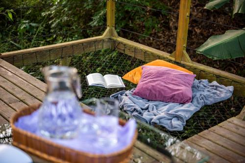 a bed with a pillow and a book on it at Refúgio Romântico - Lareira Externa, Rede suspensa, Netflix e Churrasqueira in Imbituba