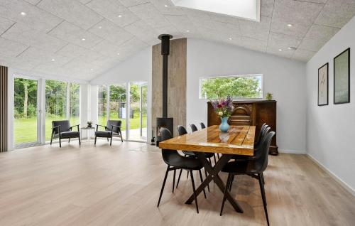 a dining room with a wooden table and chairs at 3 Bedroom Stunning Home In Spøttrup in Spottrup
