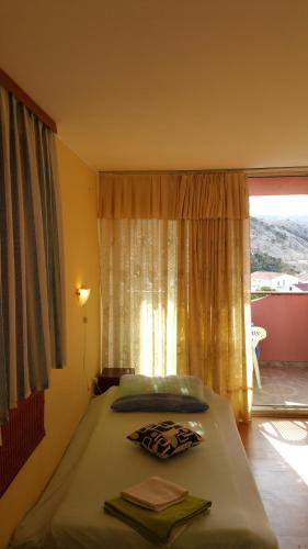 a bedroom with a bed with a large window at B&B Pansion Zlatko in Metajna