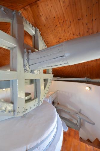 a spiral staircase in a room with a wooden ceiling at Windmill Villas in Artemonas
