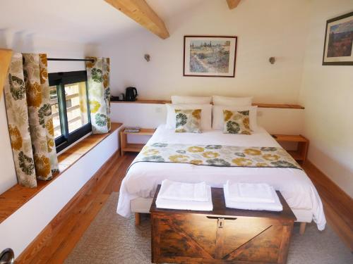 une chambre avec un grand lit et une fenêtre dans l'établissement Le Séchoir de Saint Vincent, à Saint-Vincent-le-Paluel