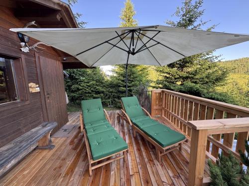 a patio with two chairs and an umbrella on a deck at ALMNEST - LACHTAL in Lachtal