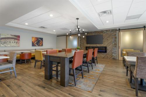 a dining room with a table and chairs and a tv at Best Western Plus Elizabethtown Inn & Suites in Elizabethtown
