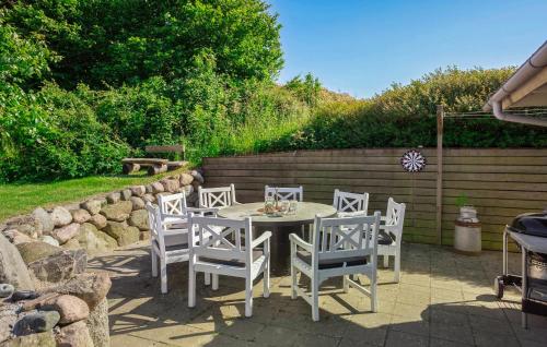 a patio with a table and chairs and a fence at Four-Bedroom Holiday Home In Rudkobing in Spodsbjerg