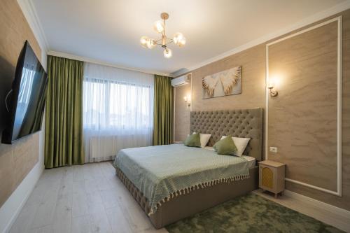 ein Schlafzimmer mit einem Bett und einem Flachbildfernseher in der Unterkunft One Studio in Focşani