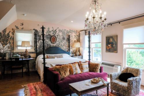 Un dormitorio con una cama con dosel y un sofá morado. en The Menagerie, en Fredericksburg
