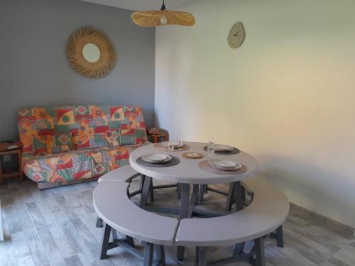 - une table avec deux chaises et un canapé dans le salon dans l'établissement Bel appartement climatisé avec balcon 200m de la Plage, à Narbonne