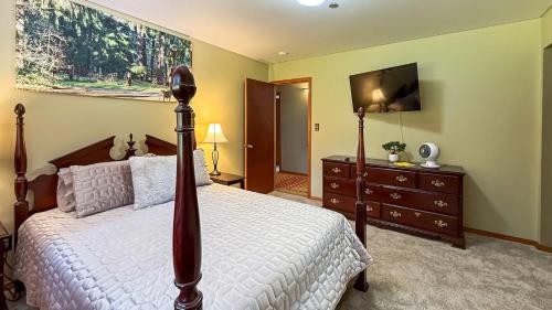 a bedroom with a bed and a dresser with a television at Evergreen Haven in Port Angeles