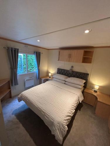 a bedroom with a large bed with two pillows at Bailey's Caravan Hire - Sealands Plot 1 - Wi-Fi - Dog Friendly in Ingoldmells