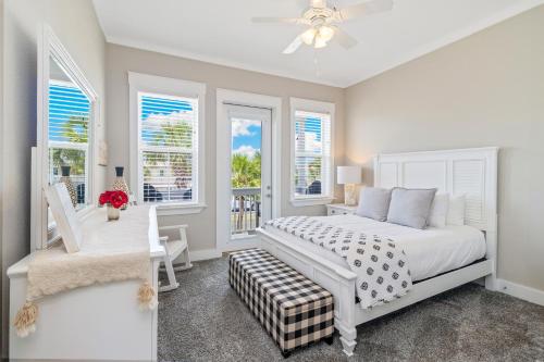 a bedroom with a white bed and windows at Two if by Sea in Mexico Beach