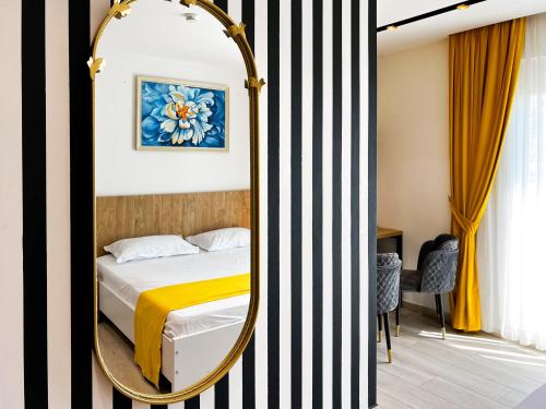 a bedroom with a bed and a mirror at Jata Hotel in Tirana