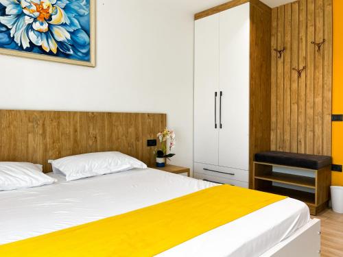a bedroom with a bed with a yellow blanket at Jata Hotel in Tirana