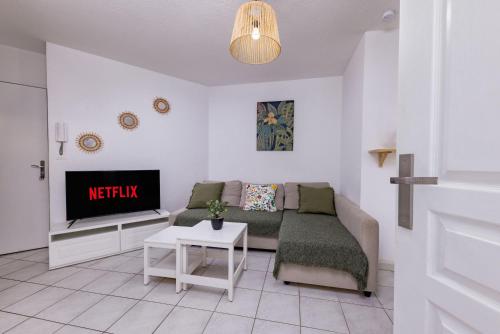 un salon avec un canapé et une télévision dans l'établissement Le Jardin du Lez - Parking Privé et Gratuit - Wifi Fibre - Rives du Lez, à Montpellier