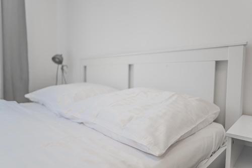 a white bed with white pillows on top of it at Heart of Prague Lodgings 3 in Prague