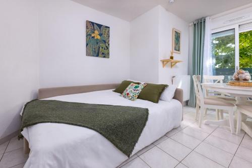 - une chambre avec un lit et une table à manger dans l'établissement Le Jardin du Lez - Parking Privé et Gratuit - Wifi Fibre - Rives du Lez, à Montpellier