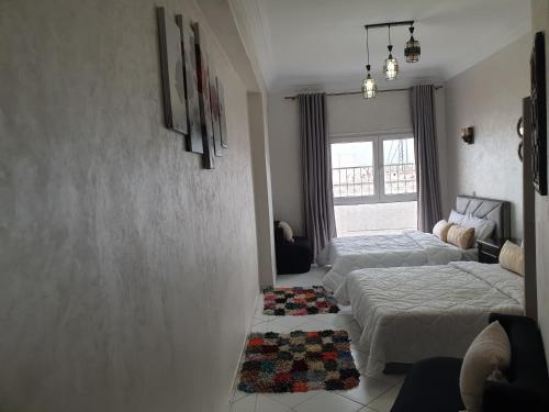 Un dormitorio con dos camas y una ventana. en Beach apartment down town, en Agadir