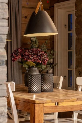 a dining room table with a vase of flowers on it at Log Cabin Near Historic Senhovd in Veggli