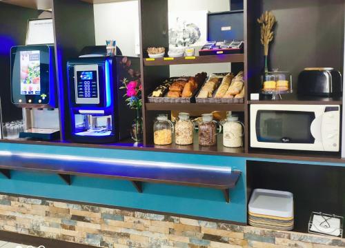 a bakery with a counter with aasteryasteryasteryasteryasteryasteryasteryasteryastery at The Originals Access, Hôtel Innostar in Labège