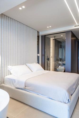 a bedroom with a large white bed and a bathroom at Keslin Premium Seaside Apartments in Vlorë