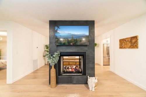a living room with a fireplace with a painting on the wall at Modern Mountain Retreat in Gatlinburg