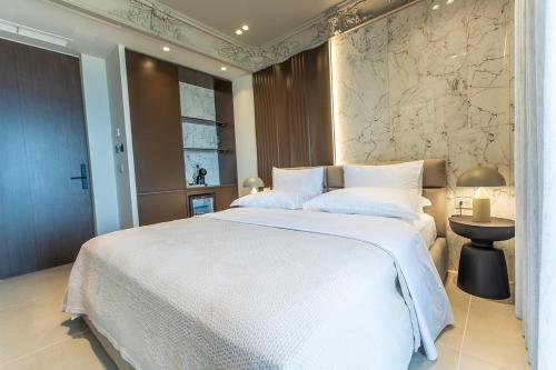 a bedroom with a large white bed and a window at Keslin Premium Seaside Apartments in Vlorë