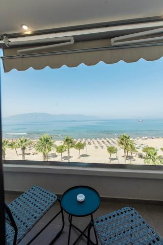 a view of a beach from a window with two chairs at Keslin Premium Seaside Apartments in Vlorë