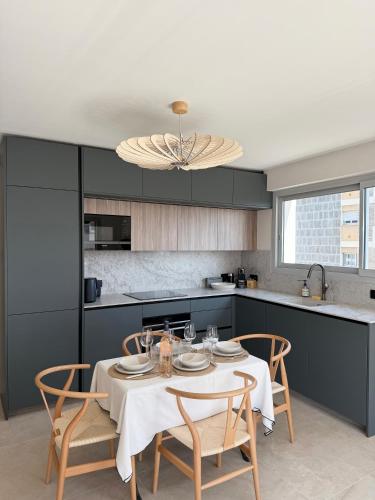 une cuisine avec une table et des chaises dans une cuisine dans l'établissement Square Croisette, à Cannes