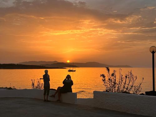 a man and a woman sitting on a wall watching the sunset at Klinakis Beach Hotel in Chania Town