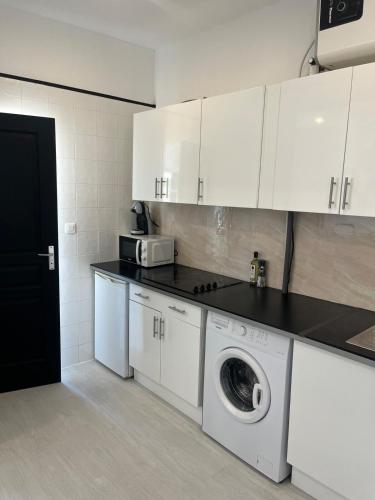 une cuisine avec des armoires blanches et une machine à laver dans l'établissement Azurian stay, à Vallauris
