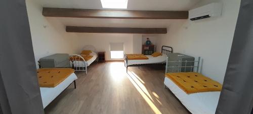 Cette chambre dispose de 4 lits et de parquet. dans l'établissement Maison de caractère en pierre, à Laurac-en-Vivarais