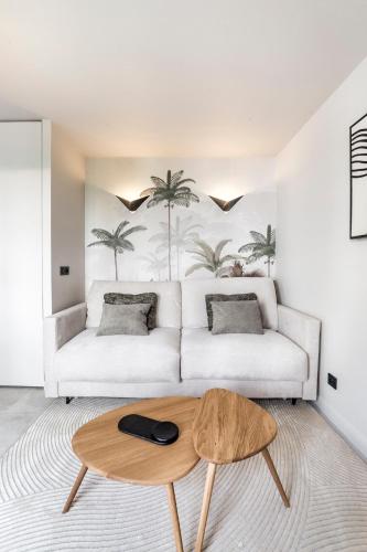 un salon avec un canapé blanc et une table basse dans l'établissement Studio Madison Valmy, à Lyon