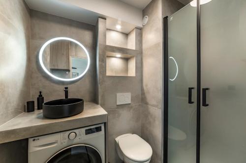 La salle de bains est pourvue d'un lave-linge et d'un miroir. dans l'établissement Studio Madison Valmy, à Lyon