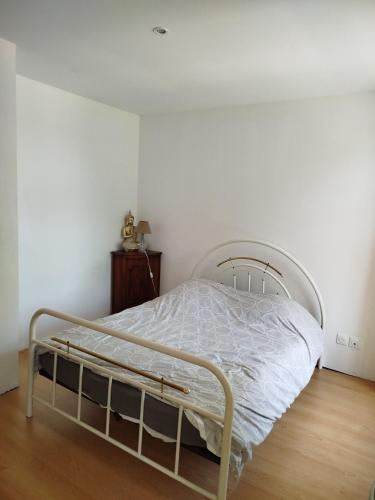 - un lit blanc dans une chambre dotée de parquet dans l'établissement Les Meublés de la Motte Obin, à Muncq-Nieurlet