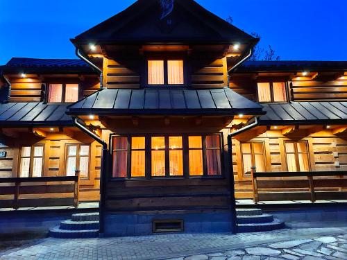 a wooden house with stairs in front of it at Chochołowskie Apartamenty -1 i Domki in Chochołów