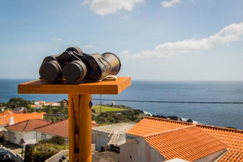 een berg verrekijkers bovenop een huis bij Casa da Vigia in Calheta de Nesquim