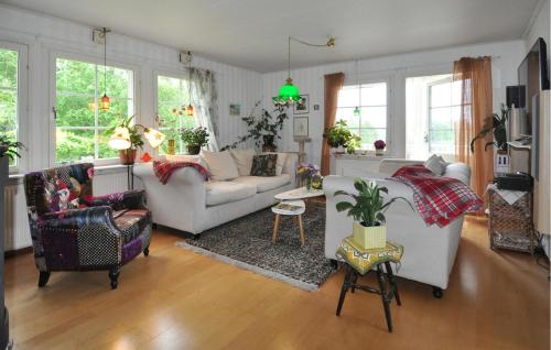 a living room with a couch and chairs and windows at Villa Utsikten in Kristinehamn