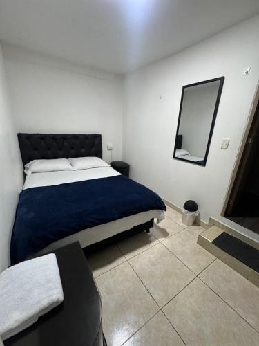 a bedroom with a bed and a mirror on the wall at Hotel Cañaveral Plaza 2 in Manizales
